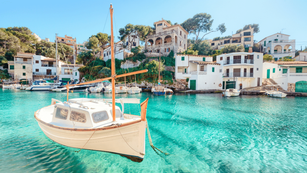 Ein Segelboot gleitet über das kristallklare Wasser von Mallorca, Spanien