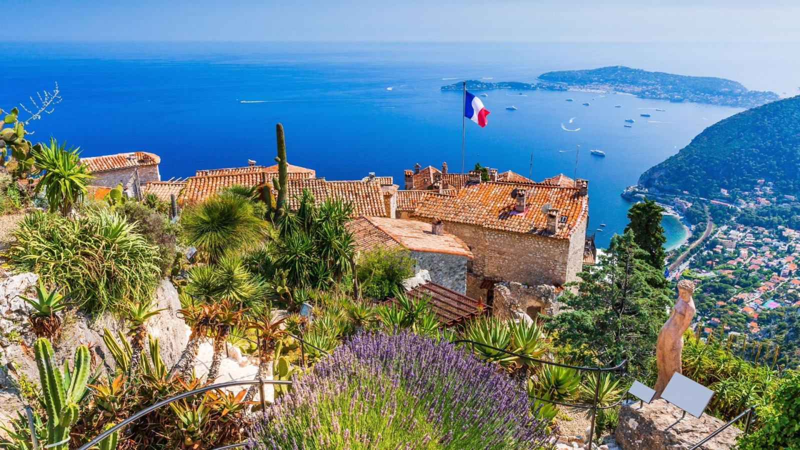 Houses on top of mountain next to the sea.